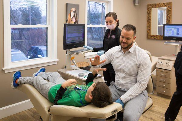 Dr. Peluso giving a high-five to a young and brave patient.