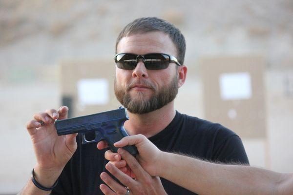 Dave Laird helping a students understand recoil control using a blue training gun.