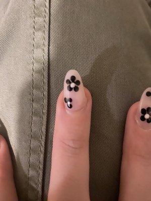 Crooked nail and one poorly done flower. (looks like a fidget spinner when both flowers were supposed to be the exact same)