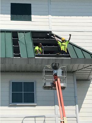 Close-up of the Titan crew repairing a roof after water damage.