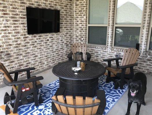 Outdoor TV mounting on brick fireplace.