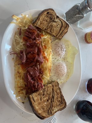 Corned beef hash with eggs, hash browns and toast