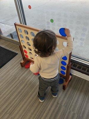 Toddler playing giant Connect 4