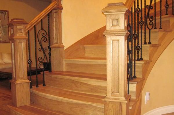 custom box newel posts with iron balusters on curved staircase installation by Splash Carpentry, Chicago IL