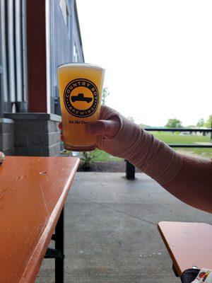 Pint of Delusions of Grandeur NEIPA and the open space surrounding the Covered Patio.