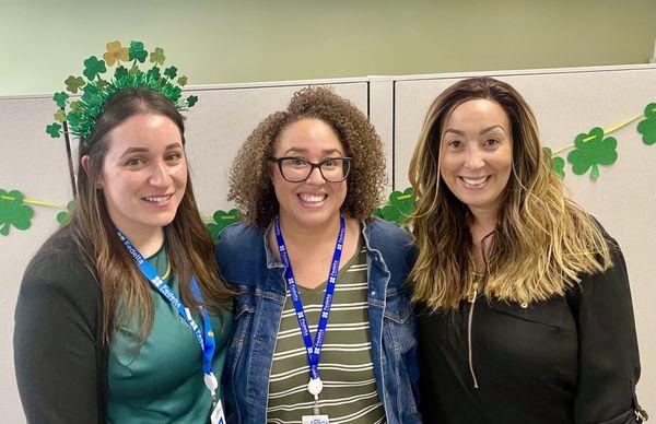 3 people smile at the St. Patrick's Day event