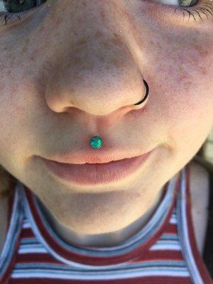 Fresh philtrum piercing by Jake Hansen, with green opal end by Industrial Strength.