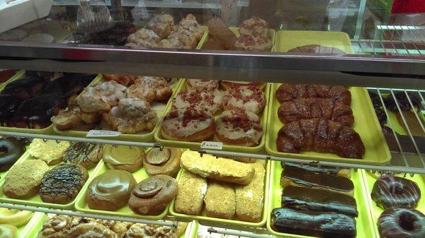 Donut selection: baked apple fritters, maple covered donuts with bacon, glazed croissants, persians, long johns.