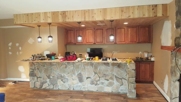 Stone bar sitting area. First stone covered wall i have done. Also built bulk head with cedar planks for the 4 pendant lights