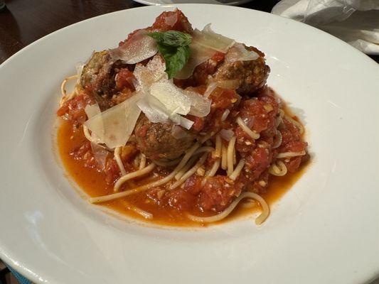 Spaghetti marinara and meatballs, fresh Parmesan shavings.