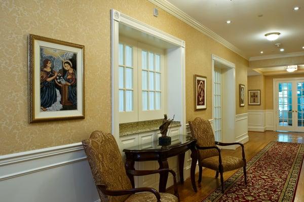 Grand hallway with custom runner, furniture, framed tapestries and Venetian plaster walls.