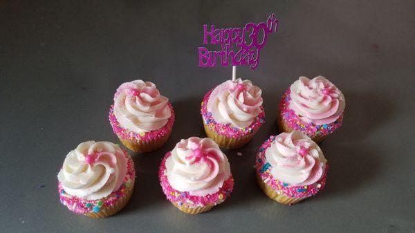 Yummy vanilla cupcakes pretty pink sprinkles and a custom topper.