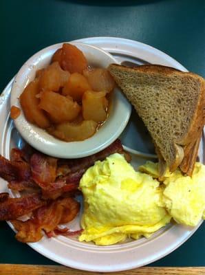 Scrambled eggs, fried apples, bacon and toast