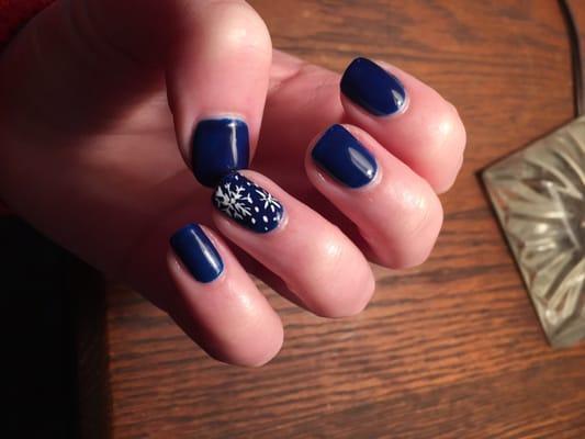 Dark blue gel manicure, with white snowflake art.