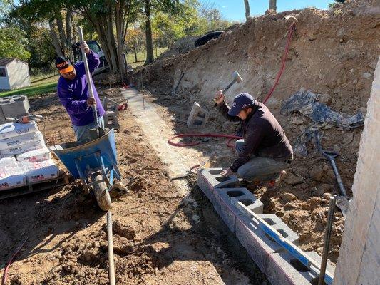 Setting the first course on the existing footing - they pinned them to the footing with rebar and epoxy