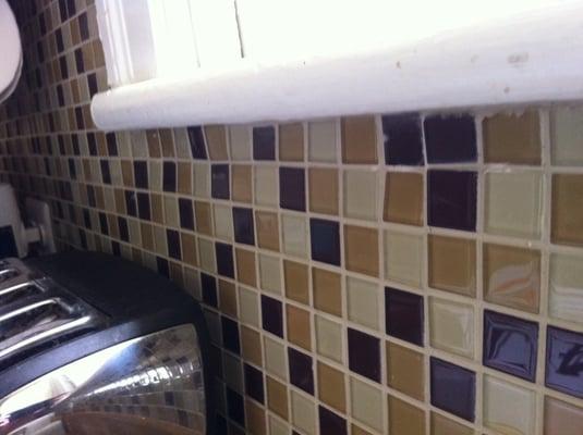 Here are some uneven tiles above our sink, the most visible spot in our kitchen.