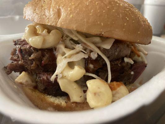 Brisket Sandwich , layered with their Smoked Mac and Cheese ,  Coleslaw and BBQ Sauce.