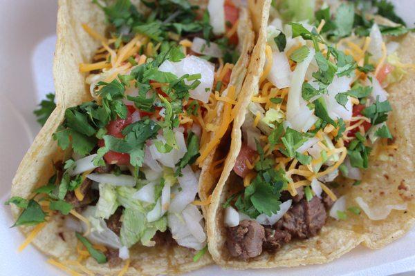 Steak tacos with everything on them; lettuce, tomato, onion, cilantro and cheese.   Your choice of toppings!