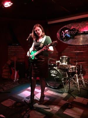 Guitar student Andrea rocks the stage at Adult Open Mic at The Grotto