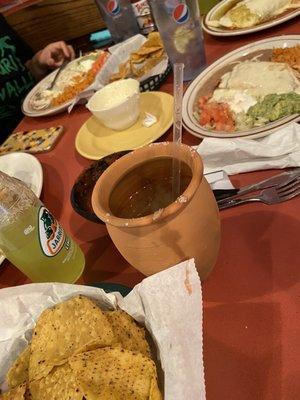 The cantarito in a clay cup and assortment of food .