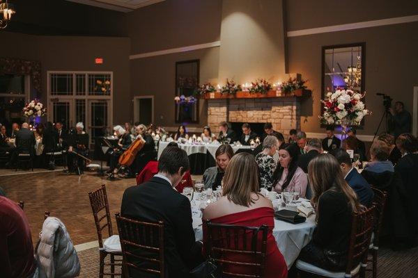 Corner of the dance floor, string trio, and head table in front of the fireplace.