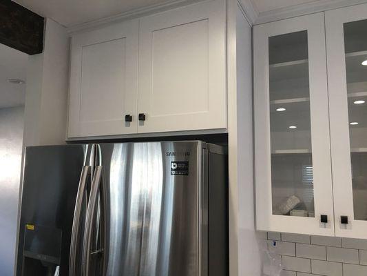 White Shaker cabinets with glass inserts.