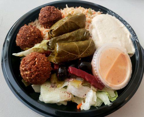 Build Your Own Mediterranean Bowl with half falafel half dolma and all vegan. The hot tahini is a must!