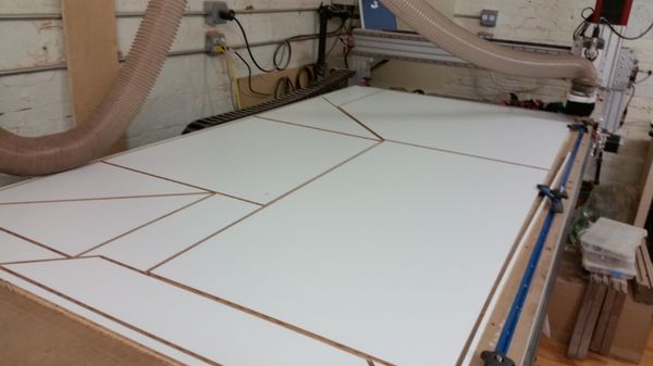 Custom cuts made on a plywood melamine sheet on the CNC.