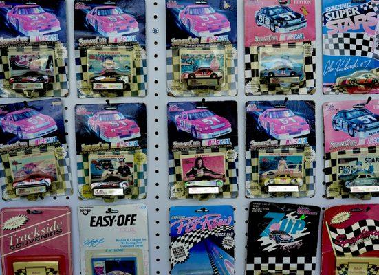 A wall of Nascars for sale.