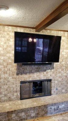 65 in TV on a brick wall with wire concealment and a soundbar attachment