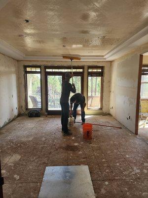 The boys are working hard at smoothing a pretextured ceiling.