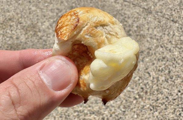 Mozzarella-stuffed soft pretzel bite.