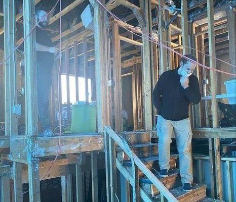 This is a photo of two SERVPRO crew members reviewing a house demolition after a severe fire. The house was completed gutted.