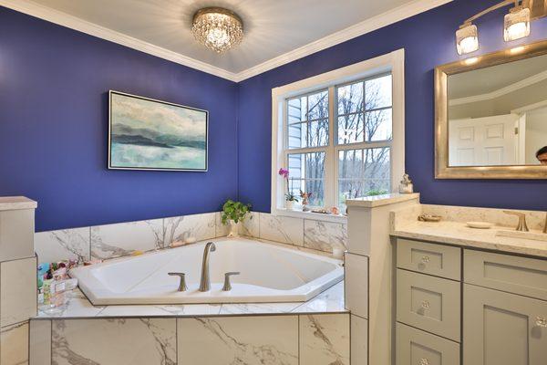 Master bathroom remodel in Frederick with corner bathtub & marble lined tiles