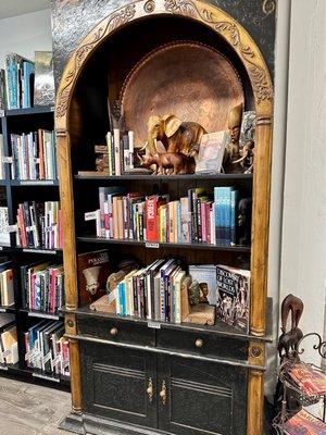 Unique wooden sculptures and handmade art among the books