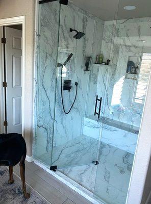 Acrylic shower remodel with bench seat and black hardware.