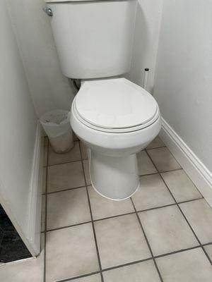 Reset customer toilet to stop leakage and clean up caulking at floor joint