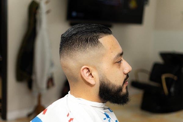 Skin fade with a razored line up, and beard clean up.