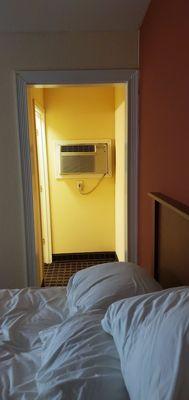 A/C unit is tucked in the small hall to the bathroom