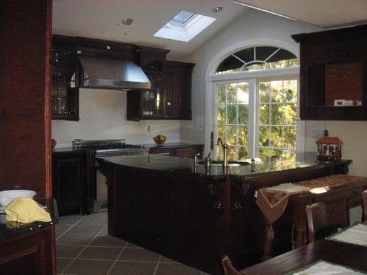 Dark cherry wood with high vaulted ceilings still needs work to finish (back splash, built in plasma flat screen...)...