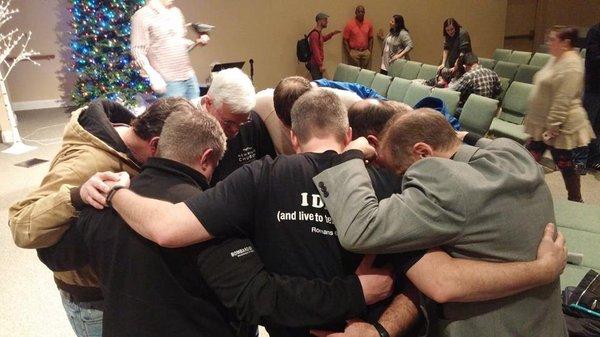 Some of our men praying together after a Sunday celebration