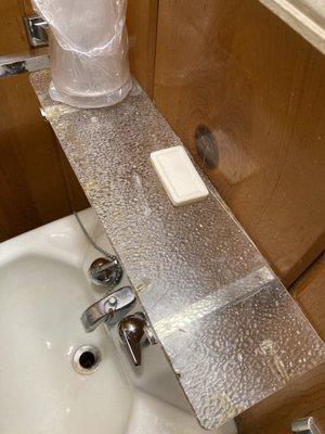 Bathroom sink. Very old and stained shelf (it's clean, but stained)