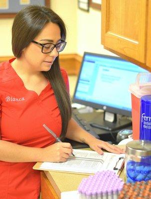 Specialist Bianca looking over a patient's paperwork.