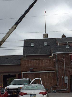 Using a crane to lift the new air conditioner