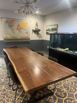 Step into our main conference rm, a comforting and inviting atmosphere: live-edge table, vintage world map, art, and captivating Pacu fish.