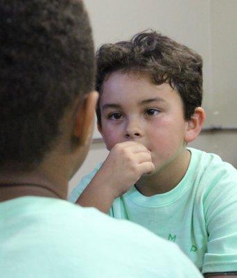 No, really, he didn't pose for this.  The kids are just that interested in each others and God's love for them.