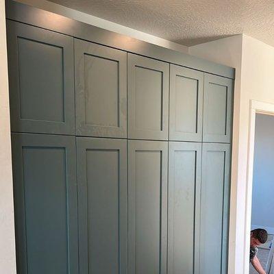 Elegant custom-built closet in a teal finish, designed to maximize space and style in any room.