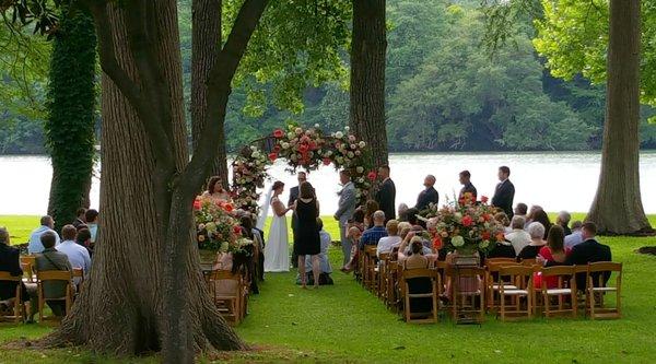 Ceremony under the tall Cedars by the water.