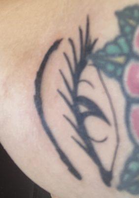 Visibly running into previous tattoo, uneven line work at the bottom, and inconsistent placement