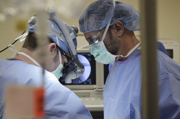 Dr. Eric Oberlander (left) and physician assistant, Shayne Brizzard in The Spine Hospital of Louisiana operating room.